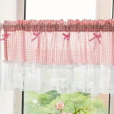 a vase with pink flowers sitting on a window sill in front of a window