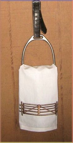 a white bag hanging from a hook on a wall