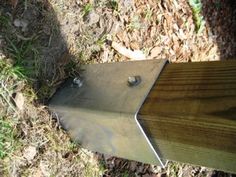 a close up of a piece of metal on the ground near grass and wood planks