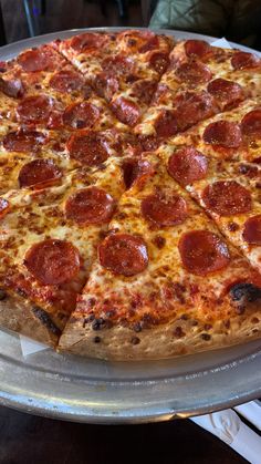 a pepperoni pizza sitting on top of a metal pan