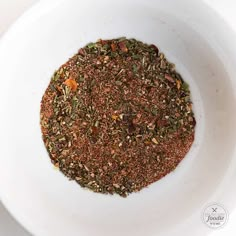 a white bowl filled with spices on top of a table