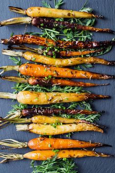 carrots with herbs and seasoning on a slate board, ready to be cooked