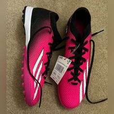 a pair of pink and black running shoes on the ground with a price tag attached