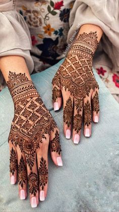 a woman's hands with hennap on her hand and the bottom half of her arm