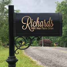 a black mailbox sitting on the side of a road