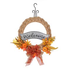 a welcome sign hanging on a door hanger with autumn leaves and ribbons around it