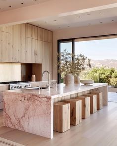 a large kitchen with marble counter tops and wooden cabinets, along with an open floor plan