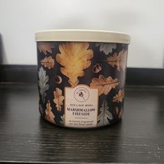 an ice cream container sitting on top of a wooden table next to a black and white wall