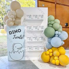 there is a display with balloons in the shape of animals and words that read dino treats