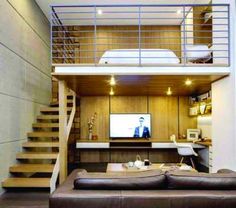 a living room filled with furniture and a flat screen tv on top of a wooden wall