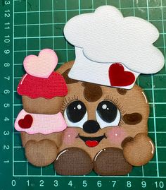 a teddy bear with a chef's hat and two cupcakes on it