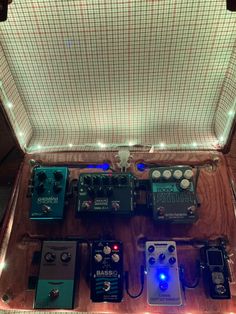 several different types of pedals and effects in an open case with lights on the sides