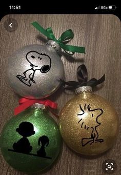 three ornament shaped like christmas ornaments with peanuts and charlie the dog on them