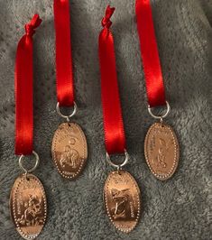 three medals with red ribbons are sitting on a blanket