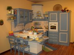 a kitchen with blue cabinets and wooden floors