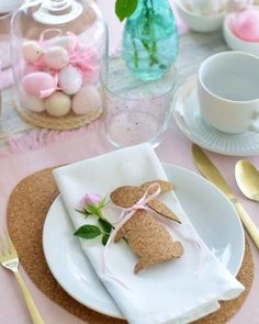 the table is set for easter dinner with pink flowers