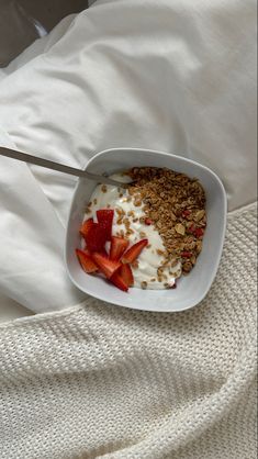 a white plate topped with granola and strawberries