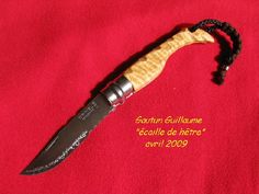 a knife that is on top of a red cloth with the words gartur guillaume