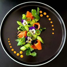 a black plate topped with lots of veggies