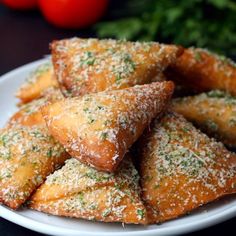 a white plate topped with pastries covered in parmesan sprinkles