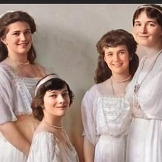 three women in white dresses posing for a photo