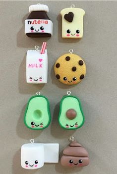 some cute little food charms hanging on the side of a wall with milk, cookies, and other items