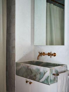 a bathroom sink sitting under a mirror next to a shower