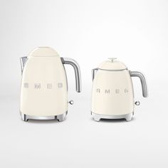 two white toasters sitting next to each other on top of a gray surface with the words smeg written on it