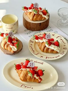 there are three croissants decorated with strawberries and whipped cream on them