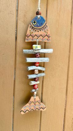 a wind chime hanging on the side of a wooden door with beads and charms