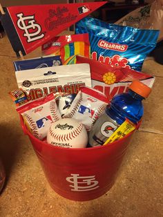 a red bucket filled with sports items on top of a counter