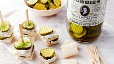 pickles and crackers are arranged on a plate next to a bottle of beer