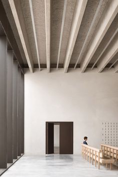 a person sitting on a bench in an empty room