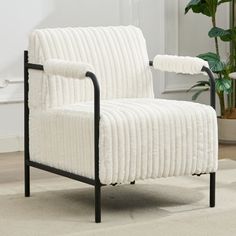 a white chair sitting on top of a carpeted floor next to a potted plant