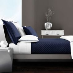 a white and blue bed in a bedroom