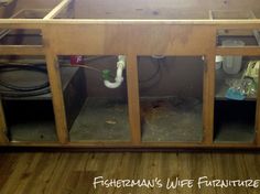 an unfinished kitchen cabinet with water marks and faucets