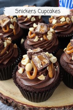 chocolate cupcakes with peanut butter and pretzel toppings on a wood slice