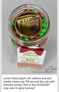 a jar filled with candy and money sitting on top of a table next to a card