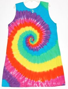 a tie - dyed tank top is hanging on a hanger, with the colors of rainbow and blue