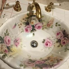 a white sink with pink flowers painted on it