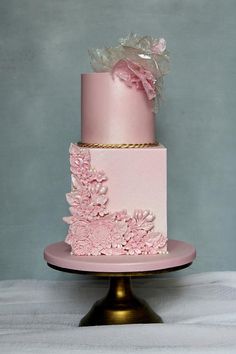 a pink and gold wedding cake with flowers on it