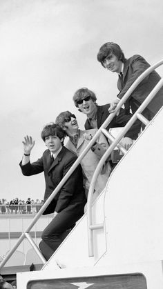 the rolling stones on an airplane with their hands in the air and one man waving