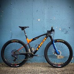 a mountain bike leaning against a blue wall