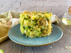 a piece of quiche on a blue plate next to an avocado slice