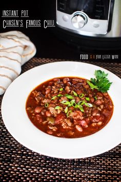 a white plate topped with chili next to an instant pot