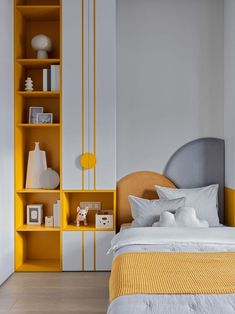 a bedroom with yellow and white decor on the shelves above the bed, along with a teddy bear