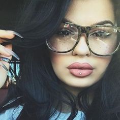 a woman wearing glasses with her nose piercing