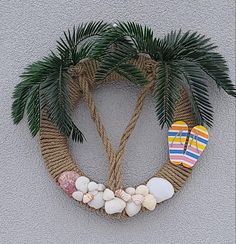 a wreath made out of rope with flip flops, palm trees and seashells