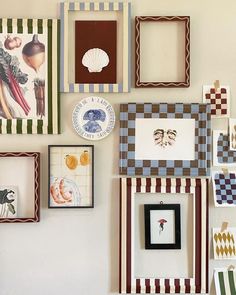 there are many different frames on the wall together, including one with an animal and shell