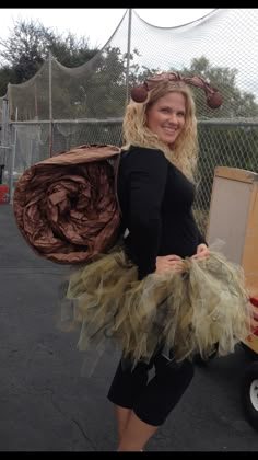 a woman in a costume is posing for the camera while holding a large piece of luggage